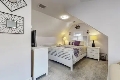 a white bedroom with a bed and a tv at Belltown Retreat in Stamford