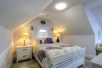 a white bedroom with a bed and a window at Belltown Retreat in Stamford