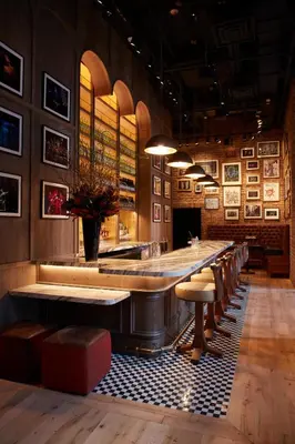 a bar in a restaurant with a long table and chairs at CIVILIAN Hotel in New York