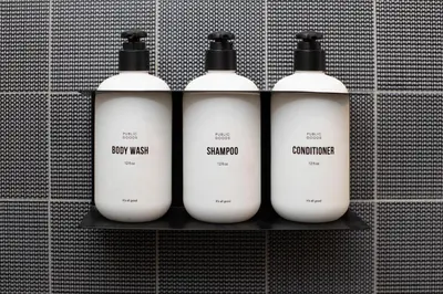a group of four white bottles on a shelf at CIVILIAN Hotel in New York