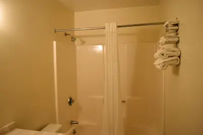 a bathroom with a shower with a shower curtain at PLYMOUTH MOTOR LODGE in Terryville