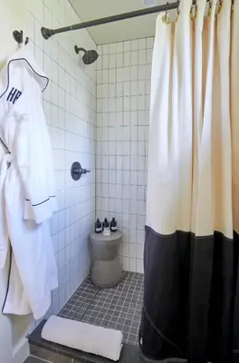 a bathroom with a shower curtain and a toilet at Hutton Brickyards Riverfront Hotel & Venue in Kingston