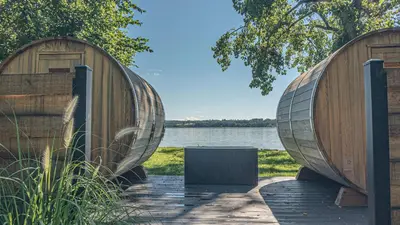 two large wooden boats sitting next to a body of water at Hutton Brickyards Riverfront Hotel & Venue in Kingston