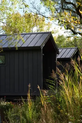 a black shed with a black roof at Hutton Brickyards Riverfront Hotel & Venue in Kingston