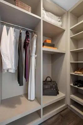 a walk in closet with white clothes and a bag at 17John in New York