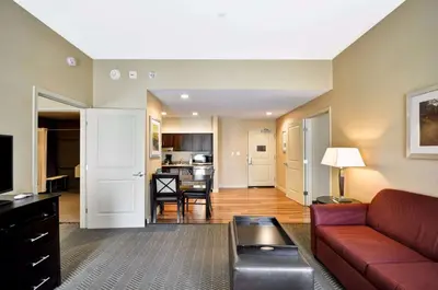 a living room with a red couch and a kitchen at Homewood Suites by Hilton Hartford / Southington CT in Southington