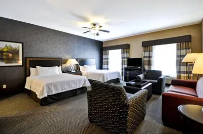 a hotel room with two beds and a couch at Homewood Suites by Hilton Hartford / Southington CT in Southington