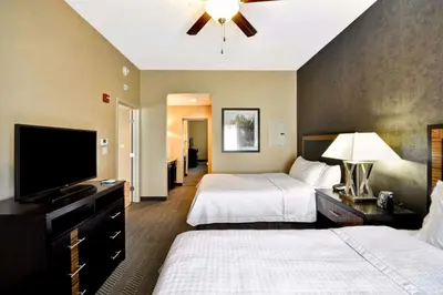 a hotel room with two beds and a flat screen tv at Homewood Suites by Hilton Hartford / Southington CT in Southington