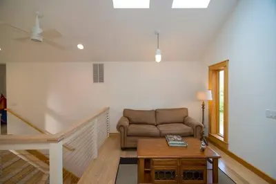 a living room with a couch and a table at Too Good AKA 2 Goodrich St in Stockbridge