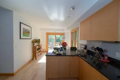 a kitchen with black counter tops and wooden cabinets at Too Good AKA 2 Goodrich St in Stockbridge