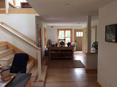 a living room with a staircase and a room with a desk at Too Good AKA 2 Goodrich St in Stockbridge