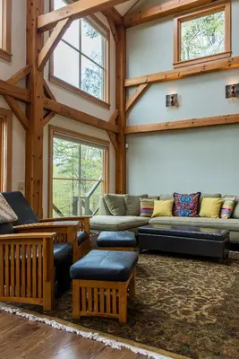 a living room with couches and tables and windows at Private Home Overlooking Stevens Lake in Great Barrington