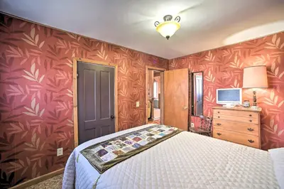 a bedroom with a bed and a red wall at Country Escape with Sauna, 10 Mi to Cooperstown in Richfield Springs