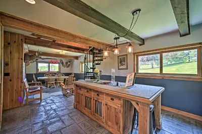 a living room with a counter and a dining room at Country Escape with Sauna, 10 Mi to Cooperstown in Richfield Springs