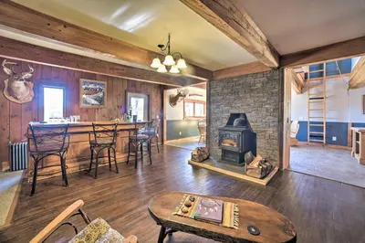 a living room with a wood stove and a table at Country Escape with Sauna, 10 Mi to Cooperstown in Richfield Springs