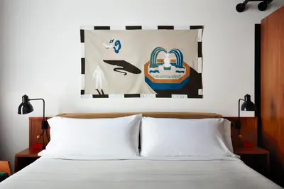 a bedroom with a bed with a poster on the wall at Ace Hotel Brooklyn in Brooklyn
