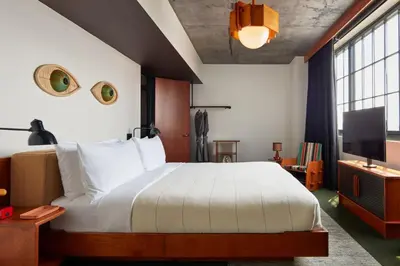 a bedroom with a large bed and a tv at Ace Hotel Brooklyn in Brooklyn