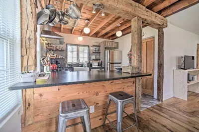 a kitchen with a large counter with two stools at Charming Cottage with Yard - 2 Mi to Tinker St! in Woodstock