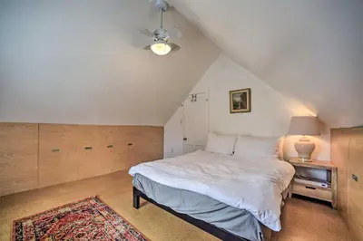 a bedroom with a large white bed in a attic at Charming Cottage with Yard - 2 Mi to Tinker St! in Woodstock