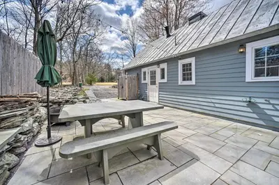 a patio with a picnic table and an umbrella at Charming Cottage with Yard - 2 Mi to Tinker St! in Woodstock