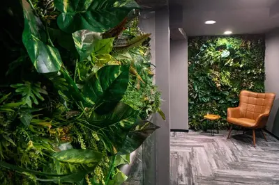 a room with a green wall with a chair and plants at Henn na Hotel New York in New York