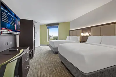 a hotel room with two beds and a flat screen tv at Hotel 1200 in Brooklyn