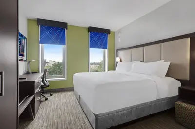 a hotel room with a bed and a desk and windows at Hotel 1200 in Brooklyn