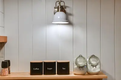 a shelf with three clocks and a light at Hilltop Walton Getaway with Picturesque Views! in Walton