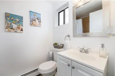 a white bathroom with a toilet and a sink at Beautiful 3 bedroom Condo in Hartford! in Hartford