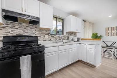 a kitchen with white cabinets and a black stove at Beautiful 3 bedroom Condo in Hartford! in Hartford