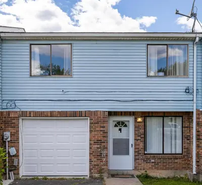 a blue house with a white garage door at Beautiful 3 bedroom Condo in Hartford! in Hartford
