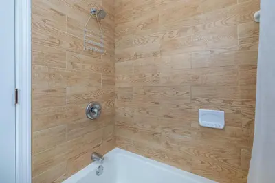 a bathroom with a shower with a white tub at Beautiful 3 bedroom Condo in Hartford! in Hartford