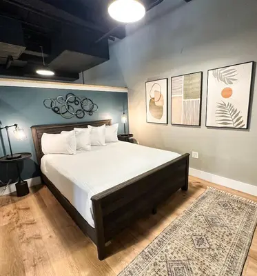 a bedroom with a large bed with white sheets at Old Mill Inn in Hatfield