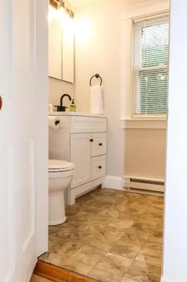 a bathroom with a toilet and a sink and a window at Old Mill Inn in Hatfield