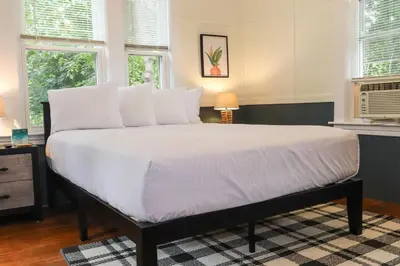 a bedroom with a large bed with white sheets and pillows at Old Mill Inn in Hatfield