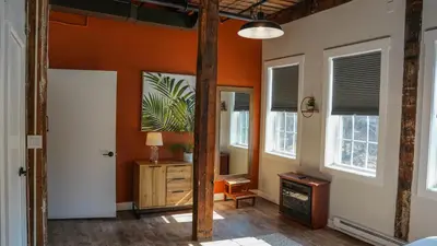 an orange room with a door and a desk and windows at Old Mill Inn in Hatfield