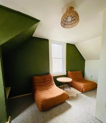 a green room with two beds and a table at Cozy Cottage with Jacuzzi, Sauna, Fire Pit and Reading Nook! in Livingston Manor