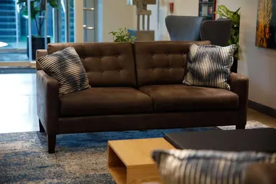 a brown leather couch in a living room at Wingate by Wyndham Bronx Haven Park in Bronx