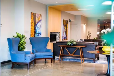 a lobby with two blue chairs and a table at Wingate by Wyndham Bronx Haven Park in Bronx