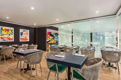 a restaurant with tables and chairs in a room at Wingate by Wyndham Bronx Haven Park in Bronx