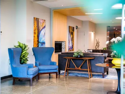 a lobby with two blue chairs and a table at Wingate by Wyndham Bronx Haven Park in Bronx