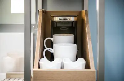 a wooden box with cups and a coffee maker at Wingate by Wyndham Bronx Haven Park in Bronx