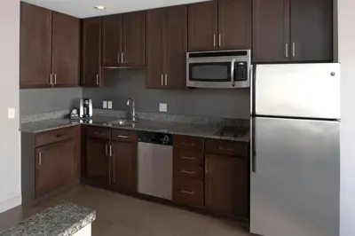 a kitchen with a white refrigerator and wooden cabinets at Residence Inn by Marriott Orangeburg in Orangeburg