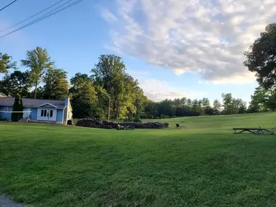 a view of a large green field with a house at Glenwood Inn - Stroudsburg in Delaware Water Gap