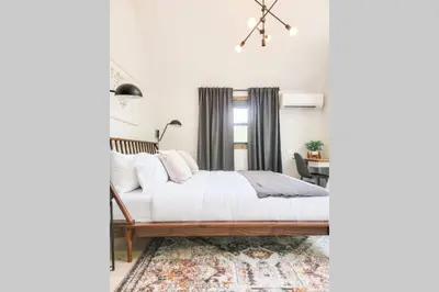 a bedroom with a bed with white sheets and a rug at Pinewood Lodge - Catskills, Windham Mountain, Hunter Mountain in Catskill