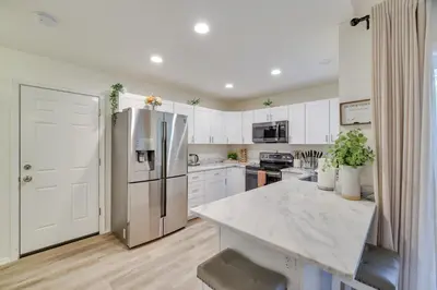 a kitchen with white cabinets and a stainless steel refrigerator at 7 Mi to Camelback Mtn Chic Penn Estates Home in East Stroudsburg