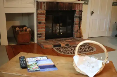 a living room with a fireplace with a book on a table at Deerfield Valley Inn - Mt Snow BnB Fireplace Rooms and Breakfast in Dover