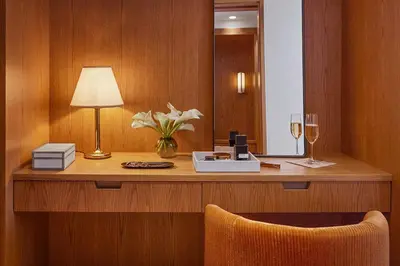 a room with a desk with a lamp and a mirror at Pendry Manhattan West in New York
