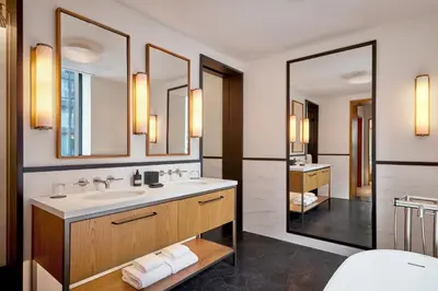 a bathroom with a sink and two mirrors at Pendry Manhattan West in New York