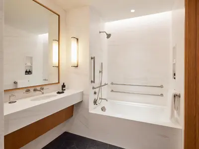 a white bathroom with a tub and a sink at Pendry Manhattan West in New York